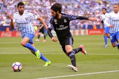 Real Madrid's Isco fights for the ball against Malaga's Luis Hernández during a Spanish La Liga soccer match between Malaga and Real Madrid in Malaga, Spain, Sunday, May 21, 2017. (AP Photo/Daniel Tejedor)
