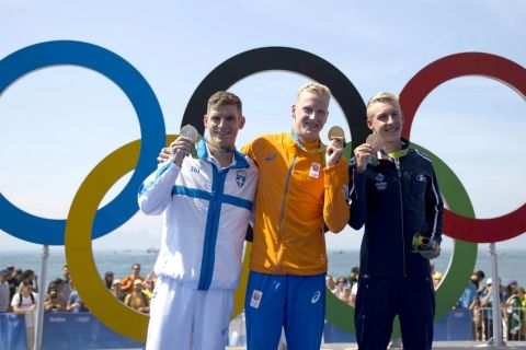 Gold medalist Ferry Weertman, of the Netherlands, center, poses for photos with silver medalist Spyridon Gianniotis, of Greece, left, and bronze medalist Marc-Antoine Olivier, of France, after the men's marathon swimming competition at the 2016 Summer Olympics in Rio de Janeiro, Brazil, Tuesday, Aug. 16, 2016. (AP Photo/Felipe Dana)