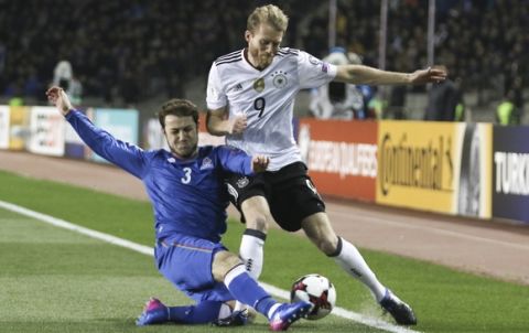 Germany's Andre Schurrle, right, and Azerbaijan's Majored Mirzabekov challenge for the ball during their World Cup Group C qualifying match at the Tofig Bahramov Stadium in Baku, Azerbaijan, Sunday March 26, 2016. (AP Photo/Aziz Karimov)