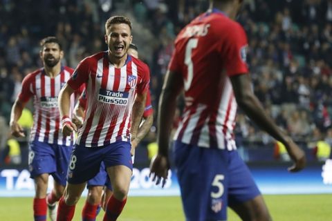 Atletico's Saul Niguez, centre, celebrates with teammates after scoring his side's third goal during the UEFA Super Cup final soccer match between Real Madrid and Atletico Madrid at the Lillekula stadium in Tallinn, Estonia, Wednesday, Aug. 15, 2018. (AP Photo/Mindaugas Kulbis)
