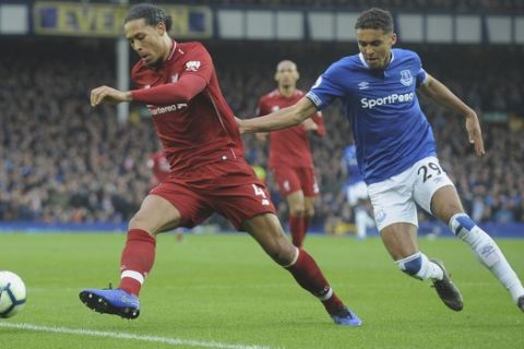Liverpool's Virgil van Dijk, left, challenges for the ball with Everton's Dominic Calvert-Lewin during the English Premier League soccer match between Everton and Liverpool at Goodison Park in Liverpool, England, Sunday, March 3, 2019. (AP Photo/Rui Vieira)