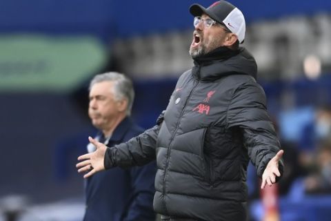 Liverpool's manager Jurgen Klopp reacts as Everton's manager Carlo Ancelotti stands in the background during the English Premier League soccer match between Everton and Liverpool at Goodison Park stadium, in Liverpool, England, Saturday, Oct. 17, 2020. (Laurence Griffiths/Pool via AP)
