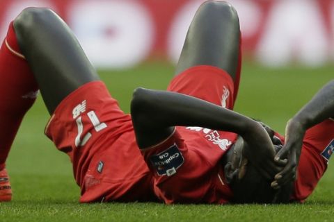 Liverpool's Mamadou Sakho holds his head after a clash of heads with his teammate Emre Can during the English League Cup final soccer match between Liverpool and Manchester City at Wembley stadium in London, Sunday, Feb. 28, 2016. (AP Photo/Tim Ireland)