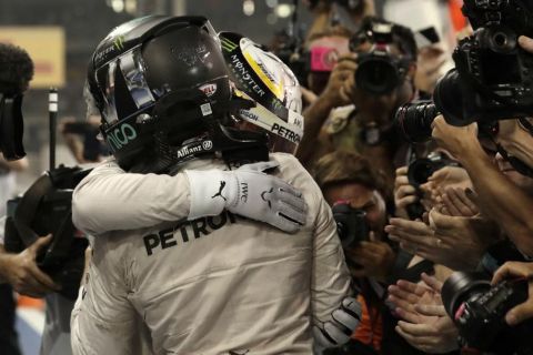 Mercedes driver Nico Rosberg of Germany cheers his teammate Mercedes driver Lewis Hamilton of Britain at the end of the Emirates Formula One Grand Prix at the Yas Marina racetrack in Abu Dhabi, United Arab Emirates, Sunday, Nov. 27, 2016. (AP Photo/Hassan Ammar)