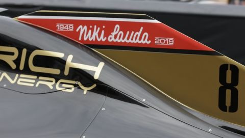 The name of three-time Formula One world champion Niki Lauda is written on Romain Grosjean's Haas race car, top, during the second practice session at the Monaco racetrack, in Monaco, Thursday, May 23, 2019. Three-time Formula One world champion Niki Lauda, who won two of his titles after a horrific crash that left him with serious burns and went on to become a prominent figure in the aviation industry, has died on May 21, 2109. He was 70. (AP Photo/Luca Bruno)