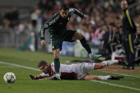 Real Madrid player Cristiano Ronaldo, top, avoids a tackle by Ajax player Toby Alderweireld during the Champions League Group D soccer match at ArenA stadium in Amsterdam, Netherlands, Wednesday Oct. 3, 2012. (AP Photo/Peter Dejong)
