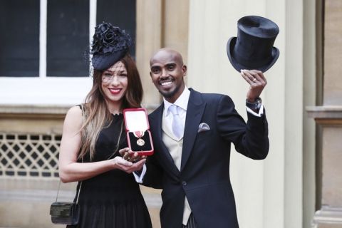 Four-time Olympic gold medalist Mo Farah poses for a photo, with his wife Tania, left, after he was awarded a Knighthood by Britain's Queen Elizabeth II at an Investiture ceremony at Buckingham Palace in London, Tuesday Nov. 14, 2017.   Farah is the most successful British distance runner track athlete in modern Olympic Games history. (Jonathan Brady/Pool via AP)