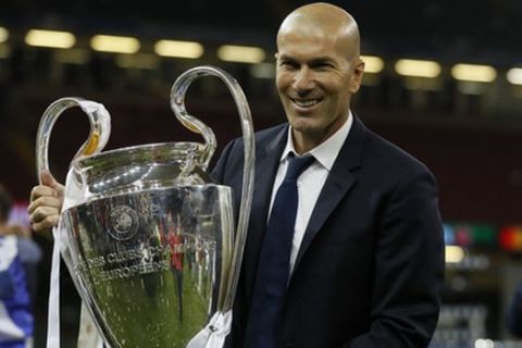 Real Madrid's head coach Zinedine Zidane holds the trophy after the Champions League soccer final between Juventus and Real Madrid at the Millennium Stadium in Cardiff, Wales, Saturday, June 3, 2017. Real Madrid won the cup. (AP Photo/Kirsty Wigglesworth)