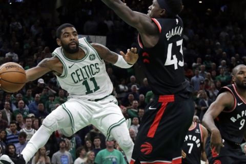 Boston Celtics guard Kyrie Irving (11) passes the ball against the defense of Toronto Raptors forwards Pascal Siakam (43) and Serge Ibaka (9) in the fourth quarter of an NBA basketball game, Friday, Nov. 16, 2018, in Boston. Irving scored 43 points to lead the Celtics to a 123-116 victory in overtime. (AP Photo/Elise Amendola)