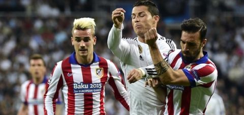 Real Madrid's Portuguese forward Cristiano Ronaldo (C) vies with Atletico Madrid's defender Jesus Gamez (R) and Atletico Madrid's French forward Antoine Griezmann (L) during the UEFA Champions League quarter-finals second leg football match Real Madrid CF vs Club Atletico de Madrid at the Santiago Bernabeu stadium in Madrid on April 22, 2015.     AFP PHOTO / GERARD JULIEN        (Photo credit should read GERARD JULIEN/AFP/Getty Images)
