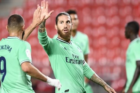 Real Madrid's Sergio Ramos, center, gestures with his teammate Benzema during the Spanish La Liga soccer match between Granada and Real Madrid at the Los Carmenes stadium in Granada, Spain, Monday, July 13, 2020. (AP Photo/Jose Breton)
