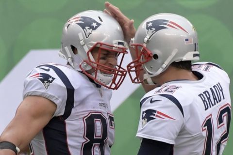 New England Patriots tight end Rob Gronkowski (87) celebrates with Tom Brady (12) after the two connected for a touchdown during the second half of an NFL football game against the New York Jets Sunday, Oct. 15, 2017, in East Rutherford, N.J. (AP Photo/Bill Kostroun)