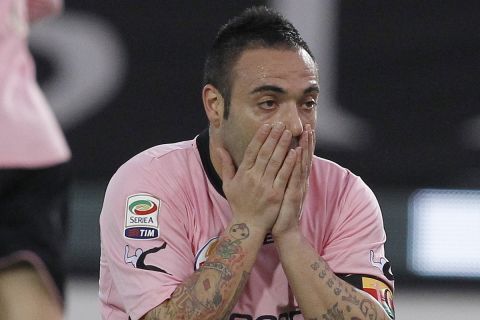 Palermo's Fabrizio Miccoli holds his face during a Serie A soccer match against Siena, in Siena, Italy, Sunday, Feb. 26, 2012. (AP Photo/Paolo Lazzeroni)