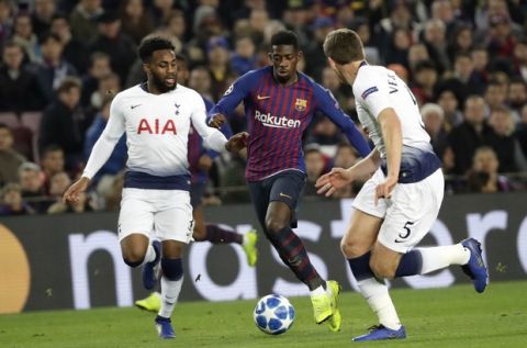 Barcelona forward Ousmane Dembele runs with the ball between Tottenham defender Danny Rose and defender Jan Vertonghen, right, during the Champions League group B soccer match between FC Barcelona and Tottenham Hotspur at the Camp Nou stadium in Barcelona, Spain, Tuesday, Dec. 11, 2018. (AP Photo/Emilio Morenatti)