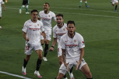 Sevilla's Lucas Ocampos, foreground, celebrates after scoring against Betis during their Spanish La Liga soccer match in Seville, Spain, Thursday, June 11, 2020. With virtual crowds, daily matches and lots of testing for the coronavirus, soccer is coming back to Spain. The Spanish league resumes this week more than three months after it was suspended because of the pandemic, becoming the second top league to restart in Europe. The Bundesliga was first. The Premier League and the Italian league should be next in the coming weeks. (AP Photo)