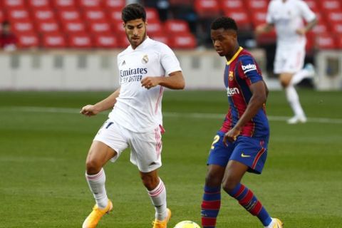 Φάση από την αναμέτρηση της Μπαρτσελόνα με την Ρεάλ για τη La Liga 2020-21 με τους Ανσού Φάτι και Ασένσιο να διεκδικούν τη μπάλα