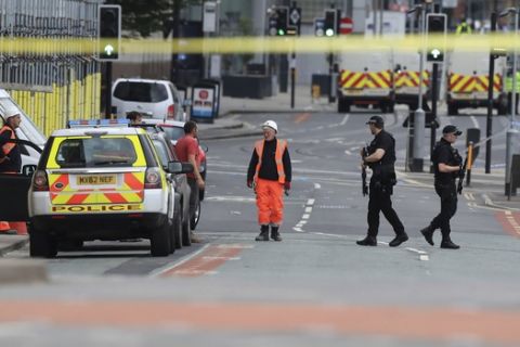 Police guard close to the Manchester Arena in Manchester, Britain, Tuesday May 23, 2017, a day after an explosion. An apparent suicide bomber set off an improvised explosive device that killed over a dozen people at the end of an Ariana Grande concert, Manchester police said Tuesday. (Peter Byrne/PA via AP)