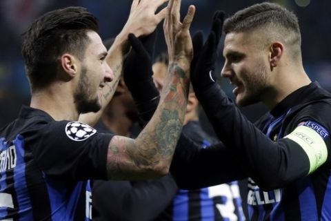 Inter Milan's Mauro Icardi, right, celebrates with his teammate Matteo Politano after scoring his side's opening goal during the Champions League, Group B soccer match between Inter Milan and PSV Eindhoven, at the San Siro stadium in Milan, Italy, Tuesday, Dec. 11, 2018. (AP Photo/Luca Bruno)