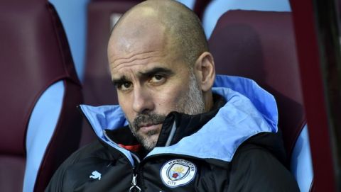 Manchester City's head coach Pep Guardiola looks out from the bench during warmup before the English Premier League soccer match between Aston Villa and Manchester City at Villa Park in Birmingham, England, Sunday, Jan. 12, 2020. (AP Photo/Rui Vieira)