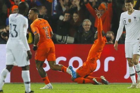Netherlands' Georginio Wijnaldum, center, right, celebrates scoring his side's first goal with Netherlands' Memphis Depay, center left, as France's Ngolo Kante, left, and France's Benjamin Pavard, right, stand defeated, during the international friendly soccer match between The Netherlands and France at De Kuip stadium in Rotterdam, Netherlands, Friday, Nov. 16, 2018. (AP Photo/Peter Dejong)