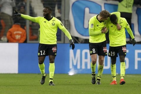 Lille's Nicolas Pepe, right, celebrates with teammates after scoring his side's second goal of the game during a French League One soccer match between Olympique Marseille and Lille at the Stade Velodrome in Marseille, France, Friday, Jan. 25, 2019. (AP Photo/Claude Paris)