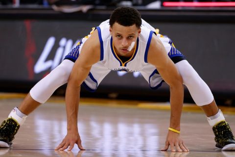 OAKLAND, CA - APRIL 02:  Stephen Curry #30 of the Golden State Warriors streches during a free throw by the Phoenix Suns at ORACLE Arena on April 2, 2015 in Oakland, California.  NOTE TO USER: User expressly acknowledges and agrees that, by downloading and or using this photograph, User is consenting to the terms and conditions of the Getty Images License Agreement.  (Photo by Ezra Shaw/Getty Images)