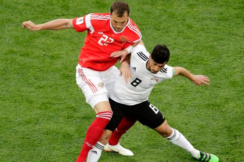 Russia's Artyom Dzyuba, left, and Egypt's Tarek Hamed challenge for the ball during the group A match between Russia and Egypt at the 2018 soccer World Cup in the St. Petersburg stadium in St. Petersburg, Russia, Tuesday, June 19, 2018. (AP Photo/Dmitri Lovetsky)