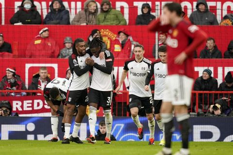 Fulham's Calvin Bassey, centre, celebrates with teammates after scoring his side's first goal during the English Premier League soccer match between Manchester United and Fulham at Old Trafford stadium in Manchester, Saturday, Feb. 24, 2024.(AP Photo/Dave Thompson)