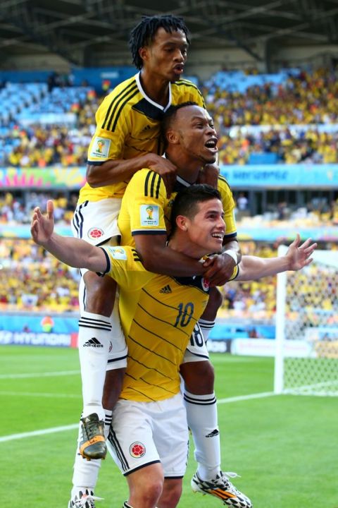BELO HORIZONTE, BRAZIL - JUNE 14:  James Rodriguez of Colombia (bottom) celebrates scoring his teams third goal with Juan Guillermo Cuadrado (top) and Juan Camilo Zuniga (middle) during the 2014 FIFA World Cup Brazil Group C match between Colombia and Greece at Estadio Mineirao on June 14, 2014 in Belo Horizonte, Brazil.  (Photo by Ian Walton/Getty Images)