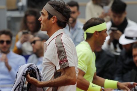 Switzerland's Roger Federer, left, and Spain's Rafael Nadal, right, walk to their benches during the changeover in their semifinal match of the French Open tennis tournament at the Roland Garros stadium in Paris, Friday, June 7, 2019. (AP Photo/Michel Euler)
