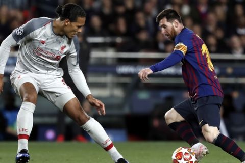 Liverpool's Virgil Van Dijk, left, vies for the ball with Barcelona's Lionel Messi during the Champions League semifinal, first leg, soccer match between FC Barcelona and Liverpool at the Camp Nou stadium in Barcelona Spain, Wednesday, May 1, 2019. (AP Photo/Joan Monfort)