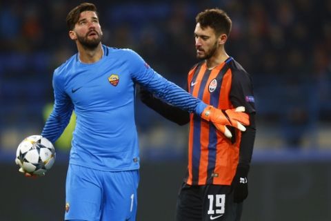 Roma goalkeeper Alisson Becker, left, discusses with Shakhtar's Facundo Ferreyra during the Champions League, round of 16, first-leg soccer match between Shakhtar Donetsk and Roma at the Metalist Stadium in Kharkiv, Ukraine, Wednesday, Feb. 21, 2018. (AP Photo/Efrem Lukatsky)