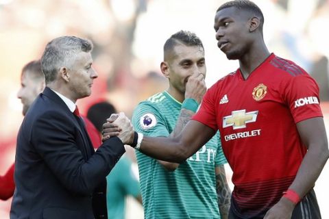 Manchester United manager Ole Gunnar Solskjaer with Paul Pogba after the final whistle during the English Premier League soccer match between Manchester United and Watford at Old Trafford Stadium, Manchester, England. Saturday, March. 30, 2019. (Martin Rickett/PA via AP)