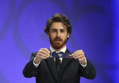 Argentina's former soccer player Pablo Aimar holds up the name of Italy during the official draw for the FIFA U-20 World Cup Korea 2017 in Suwon, South Korea, Wednesday, March 15, 2017. The FIFA U-20 World Cup Korea 2017 matches will be held in six South Korean cities from May 20 to June 11. (AP Photo/Lee Jin-man)
