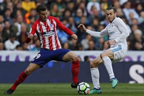Real Madrid's Gareth Bale, right, vies for the ball with Atletico Madrid's Lucas Hernandez during the Spanish La Liga soccer match between Real Madrid and Atletico Madrid at the Santiago Bernabeu stadium in Madrid, Sunday, April 8, 2018. (AP Photo/Francisco Seco)