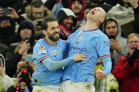 Manchester City's Erling Haaland, right, celebrates after scoring his side's third goal during the Champions League quarterfinal, first leg, soccer match between Manchester City and Bayern Munich at the Etihad stadium in Manchester, England, Tuesday, April 11, 2023. (AP Photo/Jon Super)