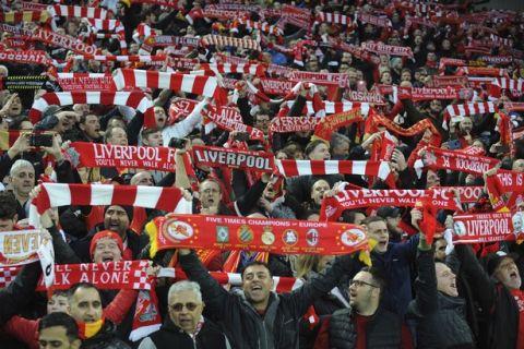 FILE - In this April 24, 2018 file photo, Liverpool fans sing "You'll Never Walk Alone" as they hold up scarves prior to the Champions League semifinal, first leg, soccer match between Liverpool and Roma at Anfield Stadium, Liverpool, England. The famous tune will be sung Saturday by 16,000-plus Liverpool fans at Olympic Stadium in Kiev, Ukraine. (AP Photo/Rui Vieira, File)