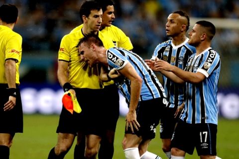 Bresnan of Brazil's Gremio and teammates argue with a linesman after Referee Andres Cunha, of Uruguay, awarded a penalty kick for Argentina's River Plate during a Copa Libertadores second leg semifinal match in Porto Alegre, Brazil, Tuesday, Oct. 30, 2018. (AP Photo/Edison Vara)