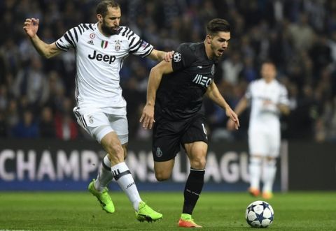 Porto's  forward Andre Silva (R) vies with Juventus' defender Giorgio Chiellini during the UEFA Champions League round of 16 second leg football match FC Porto vs Juventus at the Dragao stadium in Porto on February 22, 2017. / AFP PHOTO / FRANCISCO LEONG