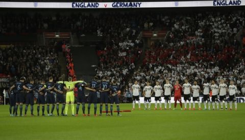 The German, right and England teams line up during a moment of silence held in remembrance for fallen armed forces personnel in service for their country before the start of the international friendly soccer match between England and Germany at Wembley stadium in London, Friday, Nov. 10, 2017. (AP Photo/Matt Dunham)