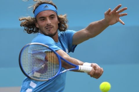 Stefanos Tsitsipas of Greece plays a return to Felix Auger-Aliassime of Canada during their quarterfinal singles match at the Queens Club tennis tournament in London, Friday, June 21, 2019. (AP Photo/Kirsty Wigglesworth)