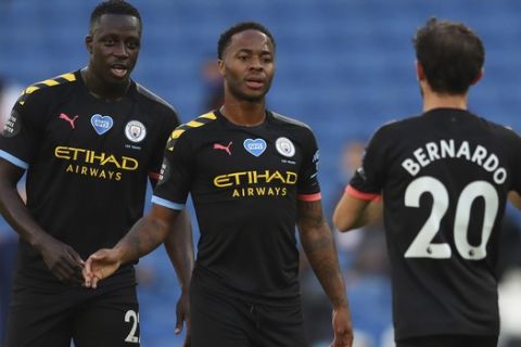 Manchester City's Raheem Sterling, center, celebrates after scoring his side's opening goal during the English Premier League soccer match between Brighton and Manchester City at the Falmer stadium in Brighton, England, Saturday, July 11, 2020. (Julian Finney/Pool via AP)