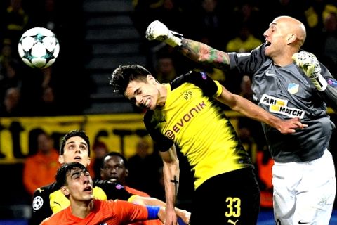 Dortmund's Julian Weigl, left center, jumps for the ball with APOEL's goalkeeper Nauzet Perez during the Champions League group H soccer match between Borussia Dortmund and APOEL Nicosia in Dortmund, Germany, Wednesday, Nov. 1, 2017. (AP Photo/Martin Meissner)