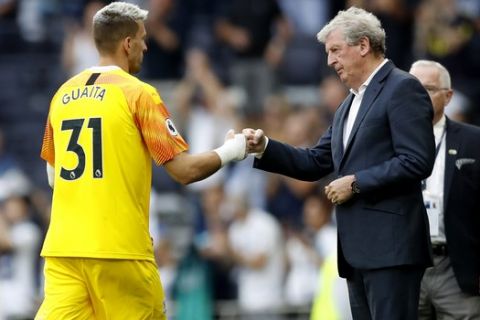 Crystal Palace's goalkeeper Vicente Guaita, left, and Crystal Palace's manager Roy Hodgson tap fists at the end of the English Premier League soccer match between Tottenham Hotspur and Crystal Palace at White Hart Lane stadium in London, Saturday, Sept. 14, 2019. (AP Photo/Alastair Grant)