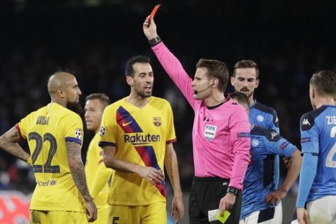 Barcelona's Arturo Vidal, left, receives the red card during the Champions League, Round of 16, first-leg soccer match between Napoli and Barcelona, at the San Paolo Stadium in Naples, Italy, Tuesday, Feb. 25, 2020. (AP Photo/Andrew Medichini)