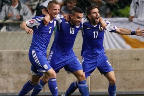 Cyprus' Constantinos Charalambides (C) celebrates with his teammates Jason Demetriou (L) and George Efrem after scoring a goal during the Euro 2016 qualifying football match against Bosnia and Herzegovina on October 13, 2015 in Nicosia.  AFP PHOTO / SAKIS SAVVIDES        (Photo credit should read SAKIS SAVVIDES/AFP/Getty Images)