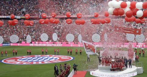 Bayern's Philipp Lahm lifts the trophy as his team celebrate winning the 27th Bundesliga title after the German first division Bundesliga soccer match between FC Bayern Munich and SC Freiburg at the Allianz Arena stadium in Munich, Germany, Saturday, May 20, 2017. (AP Photo/Matthias Schrader)
 