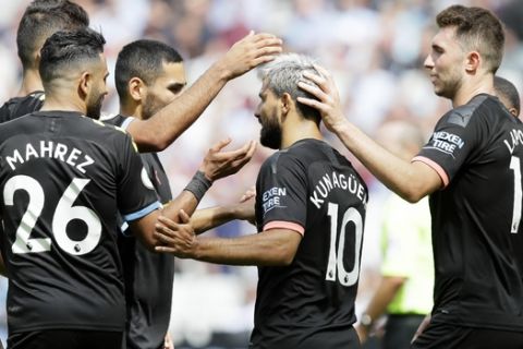 Manchester City's Sergio Aguero, center, celebrates after scoring his side's fourth goal from the penalty spot during the English Premier League soccer match between West Ham United and Manchester City at London stadium in London, Saturday, Aug. 10, 2019. (AP Photo/Kirsty Wigglesworth)