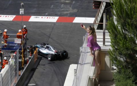 A woman takes pictures as Britain driver Lewis Hamilton steers his Mercedes during the third free practice at the Monaco racetrack, in Monaco, Saturday, May 26, 2018. The Formula one race will be held on Sunday. (AP Photo/Luca Bruno)