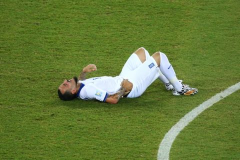 NATAL, BRAZIL - JUNE 19: Konstantinos Mitroglou of Greece lies on the field after a challenge during the 2014 FIFA World Cup Brazil Group  C match between Japan and Greece at Estadio das Dunas on June 19, 2014 in Natal, Brazil.  (Photo by Robert Cianflone/Getty Images)